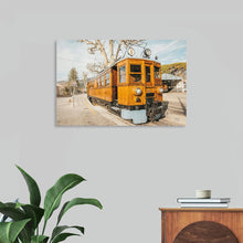  Mallorca Train by Nathan Larson is a captivating photograph that captures the timeless charm of the Sóller Railway. The vintage wooden train, bathed in warm sunlight, stands proudly at the station, surrounded by lush greenery and picturesque architecture. The image evokes a sense of nostalgia and invites the viewer to embark on a journey through the scenic landscapes of Mallorca. This stunning print is a perfect addition to any home or office looking to add a touch of European charm.