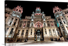  This photo captures the grandeur of the Cybele Palace in Madrid, Spain. The majestic building, bathed in the warm glow of the lights surrounding the building, presides over the bustling Plaza de Cibeles.