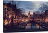 Experience the enchanting allure of Amsterdam at twilight with this captivating print. The city’s iconic canals, adorned with picturesque houses, come alive as the sun sets. 