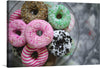 “Plate of Colorful Donuts” is a vibrant and playful artwork that captures the essence of these sweet treats. The image showcases a plate filled with various colorful donuts, each unique in its own way. A pink donut with white sprinkles is at the forefront, drawing attention due to its bright color and central placement. 