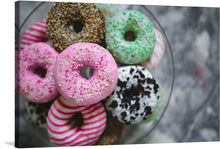  “Plate of Colorful Donuts” is a vibrant and playful artwork that captures the essence of these sweet treats. The image showcases a plate filled with various colorful donuts, each unique in its own way. A pink donut with white sprinkles is at the forefront, drawing attention due to its bright color and central placement. 