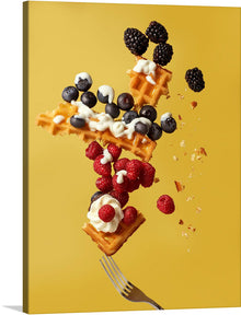  The artwork is of a waffle with raspberries, blueberries, blackberries, and whipped cream. The waffle is in mid-air, and the berries and whipped cream are falling around it. The background is yellow, and there is a fork at the bottom of the image.