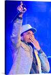 This striking portrait of Chance the Rapper performing in Red Rocks, Colorado in May of 2017 captures the energy and charisma of one of the most exciting and influential artists of our time. Chance is shown holding a microphone, his mouth covered in mid-performance. His eyes are bright and focused, and his expression is one of determination.