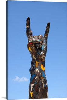  “OpenAir Festival” is a vibrant celebration of the unyielding spirit of outdoor music festivals, captured in an exquisite print. The artwork features a statue of a hand making the “rock on” gesture, painted in an eclectic mix of bold colors. This symbol, universally associated with rock music, stands against a clear blue sky, embodying the soul-stirring euphoria of pulsating beats and rhythms under the open sky. 