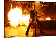  Immerse yourself in the electrifying atmosphere of a live concert with this stunning print. Every strum and note is captured in exquisite detail, as the guitarist, immersed in his artistry, commands the stage. The dramatic interplay of light and shadow, amplified by the explosive pyrotechnics, encapsulates an unforgettable performance.