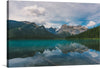 Capture the essence of pristine wilderness with this captivating print. The emerald-green surface of Yoho National Park’s serene lake beckons, a mirror to the towering granite sentinels that guard its shores. 