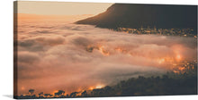  Immerse yourself in the ethereal beauty captured in this exquisite artwork. This print captures a mesmerizing dance of light and shadow, where the golden hues of a cityscape are veiled by a serene blanket of clouds, kissed by the first light of dawn. The silhouette of a majestic mountain stands as a silent witness to this enchanting interplay. Every detail, every hue is a testament to nature’s awe-inspiring ballet, frozen in time for your aesthetic pleasure. 