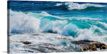  The vibrant colors and dynamic composition of the waves crashing against the rocks create a sense of energy and movement.  The image is a close up of the waves crashing against the rocks.