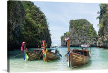  Immerse yourself in the serene beauty of this exquisite print capturing the tranquil waters of a hidden paradise. Three traditional wooden boats, adorned with vibrant ribbons, rest gently on the crystal-clear waters, offering a glimpse into a world where nature and tradition harmoniously coexist. Towering limestone cliffs, veiled in lush greenery, stand as silent sentinels guarding this secluded haven. 