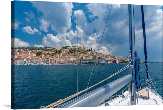 Ahoy there! Behold a picturesque sailboat gracefully gliding through the crystal-clear waters, with the charming town of Šibenik, Croatia, as its backdrop. Explore the perfect harmony between nature and civilization in this captivating image!