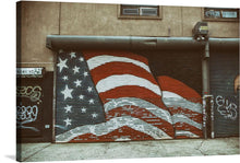  The bold colors and dynamic lines of the flag create a sense of energy and movement, making it a statement piece that is sure to start conversations. The image is a photo realistic representation of an American flag street art on a garage door. The flag is painted in red, white and blue with a wavy, dynamic design. 