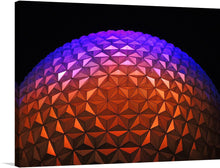  Illuminate your space with the mesmerizing glow of this exclusive art print, capturing the iconic geodesic sphere bathed in a symphony of vibrant hues. Each triangular facet dances with color, transitioning seamlessly from a warm amber glow to the tranquil embrace of lilac and violet. This artwork, a harmonious blend of architecture and light, promises to be a captivating centerpiece that ignites conversation and admiration in any modern living space. 