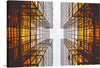 “Orange Reflective Architecture” is a limited edition print that captures the enigmatic dance of light and structure. The artwork showcases an upward view between two tall buildings with modern architectural design and glass windows that reflect an orange hue. The sky is visible in the middle, offering contrast to the orange reflections on the buildings.