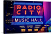 Illuminate your space with the iconic glow of New York City’s Radio City Music Hall with this vibrant print. The artwork captures the venue’s legendary marquee, bathed in radiant neon lights that spell out its name against the backdrop of the city’s dynamic nightlife. Every line and curve of the glowing letters, set against a deep blue sky, invites you into a world where art and music come to life. 