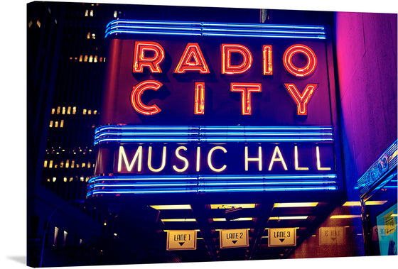 Illuminate your space with the iconic glow of New York City’s Radio City Music Hall with this vibrant print. The artwork captures the venue’s legendary marquee, bathed in radiant neon lights that spell out its name against the backdrop of the city’s dynamic nightlife. Every line and curve of the glowing letters, set against a deep blue sky, invites you into a world where art and music come to life. 