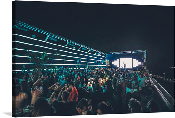 This photograph captures the excitement and energy of a crowd of people dancing while DJ Bibb plays live at the ODD rooftop in summer of 2021. The dancers are from all walks of life, but they are all united by their love of music and dance.