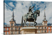  Immerse yourself in the grandeur of historical architecture and artistry with this exquisite print. The artwork captures a majestic bronze statue of a valiant figure, poised atop a gallant steed, set against the backdrop of an ornate European edifice. Every intricate detail, from the graceful posture of the horse to the intricate engravings on the building, is rendered with impeccable clarity.