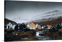  This stunning print captures the serene and captivating landscape of Eysturoy, Faroe Islands. The Nordic houses, painted in a symphony of colors, stand as a testament to the harmonious blend of tradition and the rugged beauty of nature. The snow-capped mountains stand majestically in the background, their white peaks contrasting beautifully with the dark, cloudy skies.