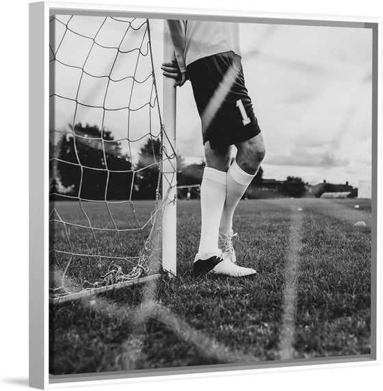 "Male goalkeeper standing by the goal"