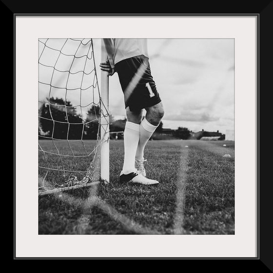 "Male goalkeeper standing by the goal"