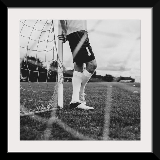 "Male goalkeeper standing by the goal"