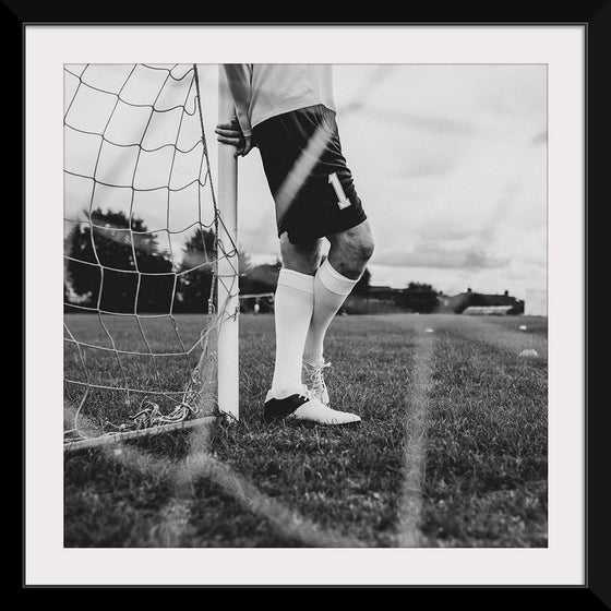 "Male goalkeeper standing by the goal"