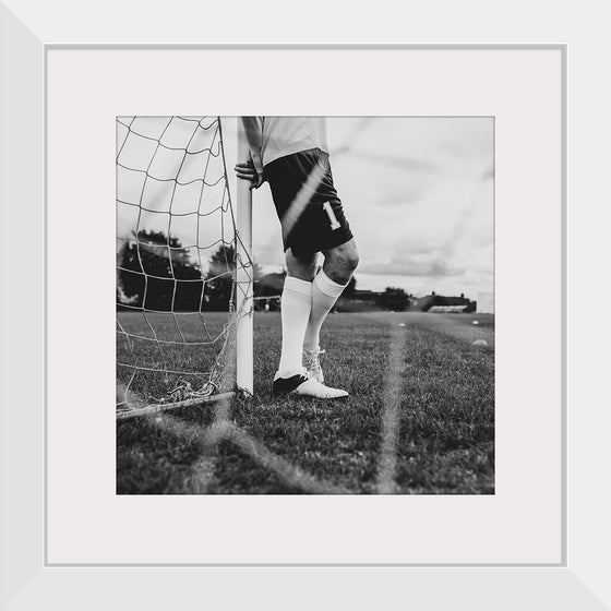 "Male goalkeeper standing by the goal"