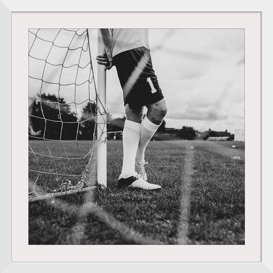 "Male goalkeeper standing by the goal"