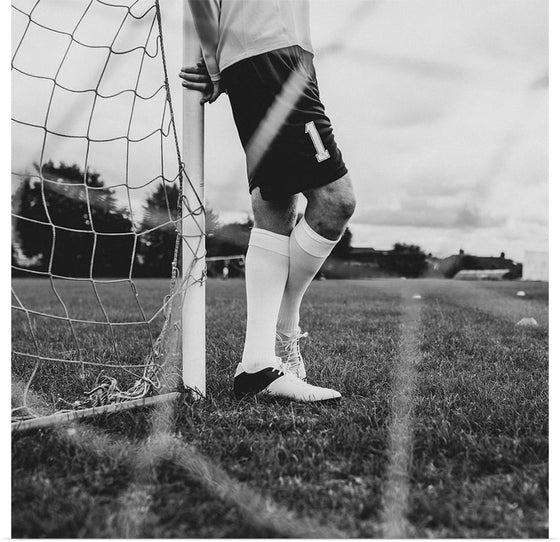 "Male goalkeeper standing by the goal"