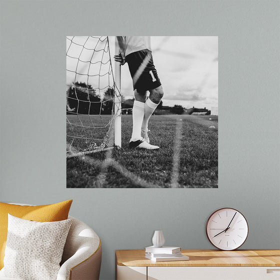 "Male goalkeeper standing by the goal"