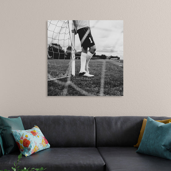 "Male goalkeeper standing by the goal"