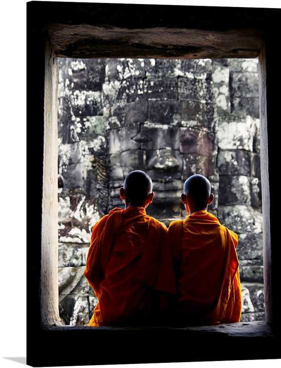 Immerse yourself in the serene and spiritual ambiance captured in this exquisite print. Two monks, adorned in vibrant orange robes, sit side by side in silent contemplation. They are framed by the rugged outlines of an ancient stone window, their gaze fixed upon a majestic, time-worn visage carved into the stone beyond. 