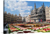 Immerse yourself in the enchanting allure of “Grand Place Brussels Belgium,” a captivating print that transports you to the heart of Europe’s architectural and cultural splendor. Every detail, from the intricate floral carpet adorned with vibrant blossoms to the majestic, historical edifices that stand as silent witnesses to time’s passage, is captured with exquisite clarity. 