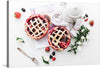 This print is a beautiful and mouth-watering image of two freshly baked pies. The pies are surrounded by fresh berries and flowers, making it a perfect addition to any kitchen or dining space. The photo-realistic image showcases two round pies with a lattice crust on top. The pies are adorned with fresh strawberries, blackberries, and raspberries, and there are white flowers scattered around them. 