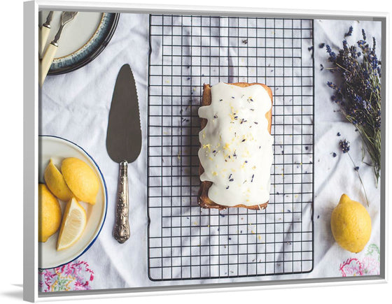 "Freshly baked lemon cake with icing and lavender flowers"