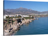 This artwork, titled “Nerja vue depuis le balcon d’Europe,” is a stunning representation of the picturesque town of Nerja, as viewed from Europe’s balcony. The artwork captures the essence of Nerja’s natural beauty, with its rugged cliffs, azure waters of the Mediterranean Sea, and majestic mountains. 