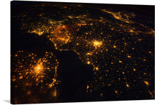  This stunning print titled “Northwestern Europe at Night” is a captivating visual journey that brings the celestial view of our world into your home. The image captures Northwestern Europe as seen from space during nighttime. Bright city lights are prominently visible against a dark backdrop representing landmasses and bodies of water. 