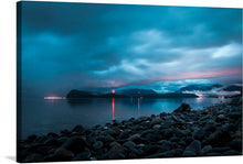 “Juneau, United States” is a captivating artwork that encapsulates the tranquil and mystical allure of Alaska’s capital. The artwork features a serene and moody scene at dusk or dawn by the water in Juneau, United States. In the foreground, there are numerous smooth rocks that appear wet or glossy.