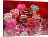 This captivating print features a collection of heart-shaped treats, each meticulously adorned with sprinkles, drizzles, and glitter. The radiant red backdrop enhances the visual appeal of these confectionery masterpieces, making the artwork a vibrant and delightful visual feast. Each treat, mounted on a stick wrapped with pink ribbons, exudes an atmosphere of love and celebration. 