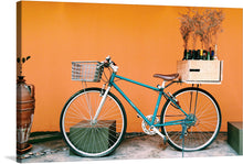  “Old Bicycle Meets Designer” is a captivating artwork that marries vintage charm with modern aesthetics. In this piece, an old yet elegant bicycle, painted in a rich teal hue, stands against a vibrant orange backdrop. The bicycle is not just a mode of transport but an artifact of simpler times, evoking nostalgia and warmth.