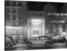  “Cars on the Champs-Elysées” is a stunning black and white photograph of the iconic Parisian street. The image captures the elegance and grandeur of the city, with vintage cars parked along the tree-lined boulevard. 