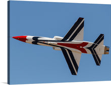  Elevate your space with the “Talon Alliance Air Show 2014” print, capturing the majesty and precision of aviation at its finest. This stunning piece features a jet, adorned in a striking red, white, and blue color scheme, soaring gracefully against the backdrop of an immaculate azure sky.