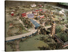 Step into a world where tradition meets tranquility with this exquisite artwork print. The piece captures a meticulously crafted miniature landscape, showcasing an idyllic Asian village nestled amidst lush greenery. A serene river meanders through the settlement, reflecting the elegant architecture of red and white buildings and an imposing multi-storied pagoda that stands as the centerpiece. 