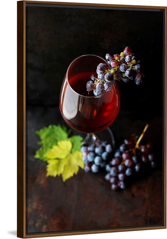 "Macro view of a wine glass containing alcoholic wine with a bunch of grapes."