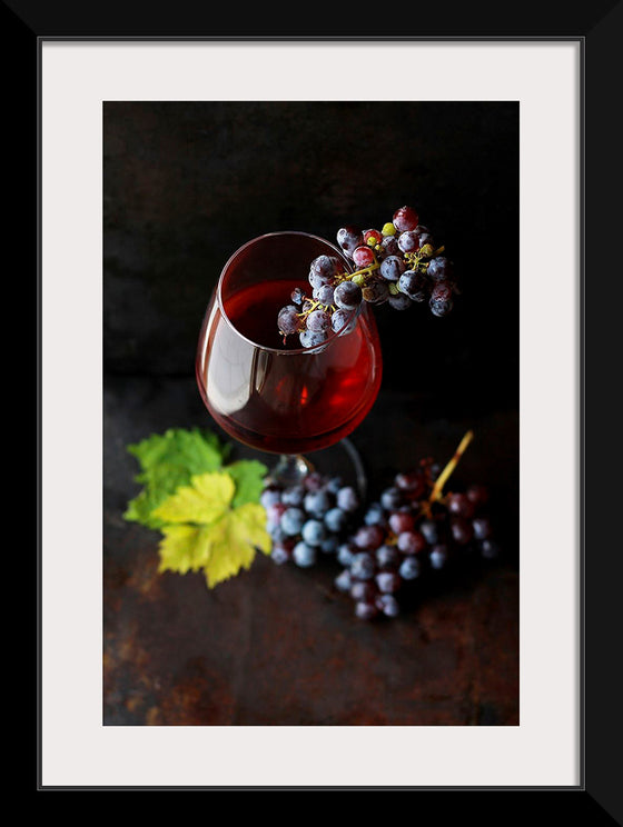 "Macro view of a wine glass containing alcoholic wine with a bunch of grapes."