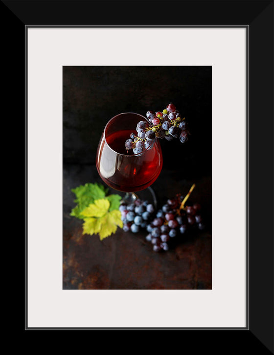 "Macro view of a wine glass containing alcoholic wine with a bunch of grapes."