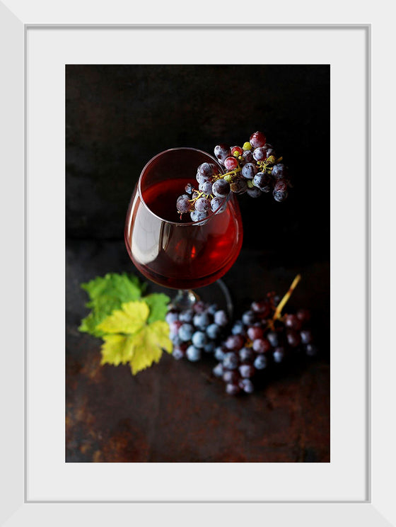 "Macro view of a wine glass containing alcoholic wine with a bunch of grapes."