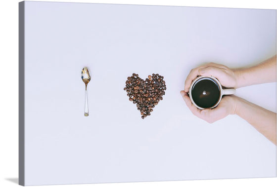 A meticulously arranged heart of rich, brown coffee beans lies between a gleaming spoon and hands tenderly cradling a cup of freshly brewed coffee. Every element is captured with stunning clarity against a pristine white backdrop, evoking a sense of purity and undisturbed tranquility.