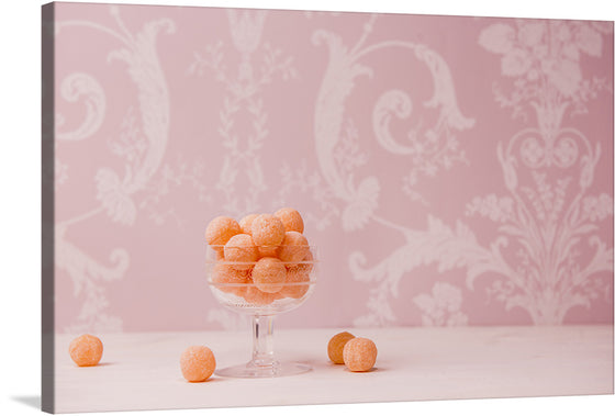 This print is a delightful blend of elegance and whimsy, perfect for adding a touch of charm to any space. It features a pastel pink backdrop adorned with intricate white floral patterns, contrasting beautifully with the playful scattering of orange gumballs from a clear pedestal bowl. 