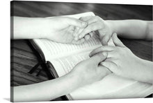  “Praying Together” is a serene and intimate artwork that captures a moment of deep reflection and tranquility. The image features two pairs of hands gently touching each other over an open book, suggesting prayer or deep connection. The monochromatic tones enhance the timeless essence, making it a perfect addition to any space seeking an element of tranquility and inspiration.